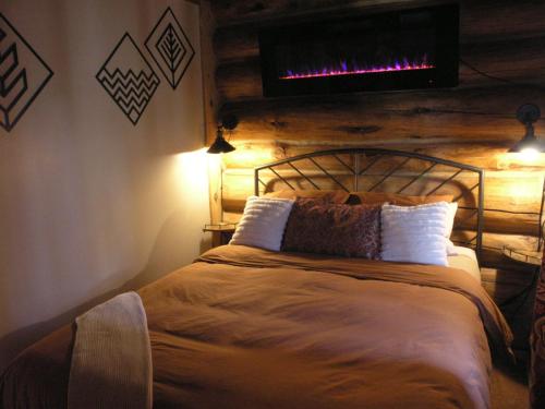 博尔德博尔德牧场山区旅馆的卧室配有一张床铺,墙上配有电视