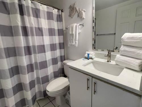 奥兰治比奇Tradewinds 908的浴室配有水槽、卫生间和浴帘