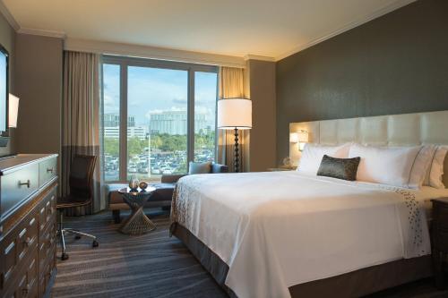 坦帕坦帕国际广场万丽酒店的一间酒店客房,设有一张大床和一个大窗户