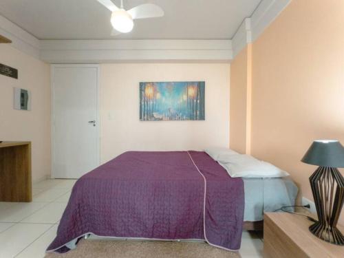 马林加Apartamento Wifi Smart - CID517A的一间卧室配有紫色的床,墙上挂着一幅画