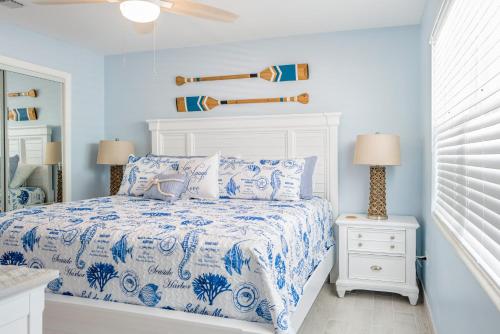 马拉松Waterfront with Boat Lift/Kayaks and Hot Tub的一间卧室配有一张带蓝色和白色棉被的床
