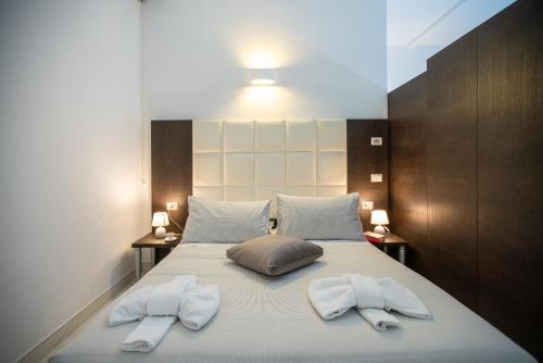 罗马Morin 10 Rome Exclusive Suites的一间卧室配有一张床,上面有两条毛巾