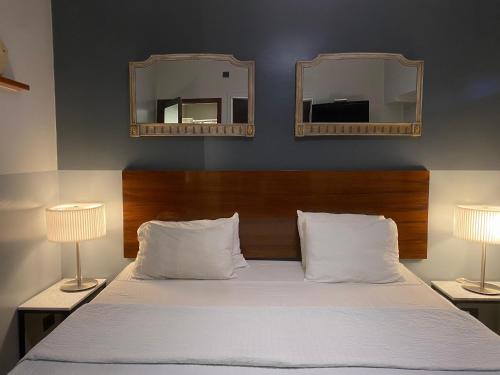 埃塞萨EZE Inn Boutique Hotel的卧室配有一张床铺,墙上挂有两面镜子