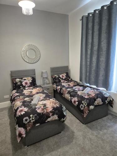 布莱克浦Luxury Town House的一间卧室设有两张床和窗户。
