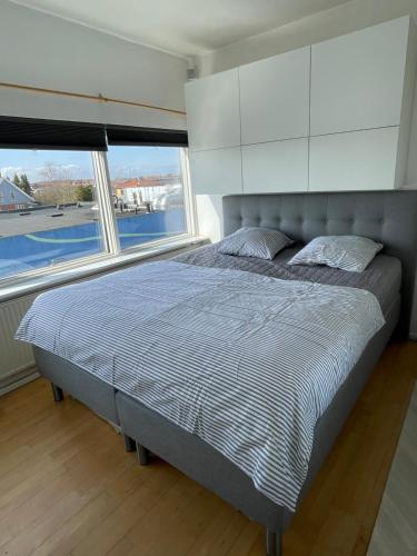 哥本哈根VS-Guesthouse的卧室内的一张床位,设有两个大窗户