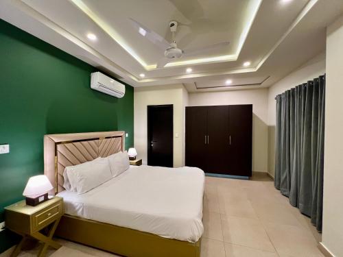 伊斯兰堡Serenity Corner 4 BHK的卧室配有白色的床和绿色的墙壁