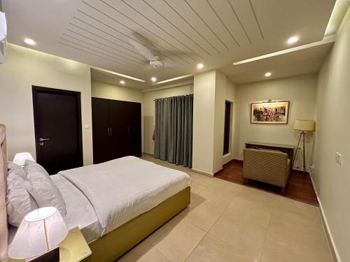 伊斯兰堡Serenity Corner 4 BHK的卧室配有一张白色大床和一张书桌