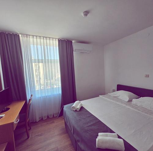 塞扎纳塔博尔酒店的一间卧室配有一张床、一张书桌和一个窗户。