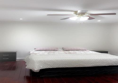 布兰普顿Beautiful private Room near Airport的一间卧室配有一张带吊扇的床