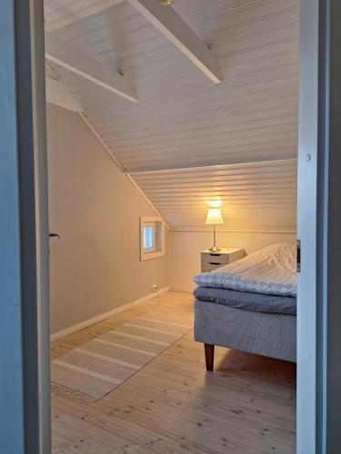 Yö Vaahteramäellä的一间卧室,卧室内配有一张床和一盏灯