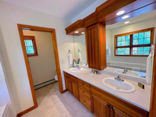 布雷顿森林SH1 Beautiful StoneHill Townhouse in Bretton Woods的一间带两个盥洗盆和大镜子的浴室
