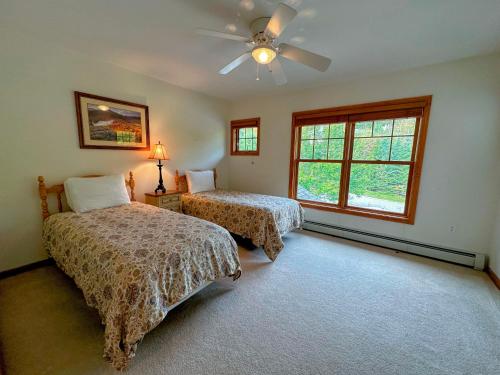 布雷顿森林SH1 Beautiful StoneHill Townhouse in Bretton Woods的一间卧室配有两张床和吊扇