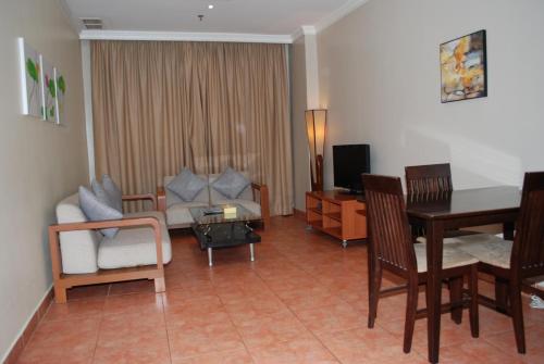 科威特时代广场套房酒店的客厅配有沙发和桌椅