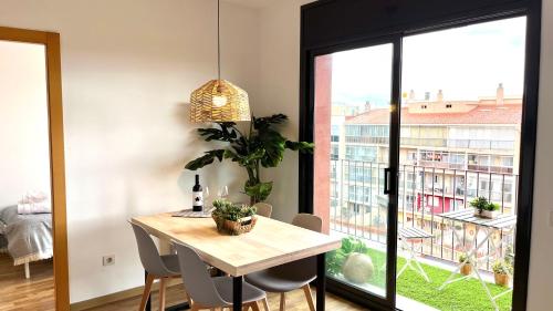 特拉萨APARTAMENTO CON TERRAZA BY PRESTIGI的一间带桌子和大窗户的用餐室