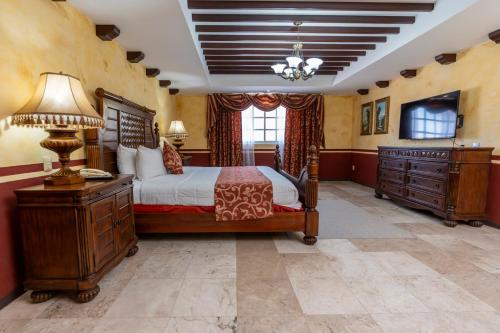 坎佩切海景酒店的一间卧室配有一张床、一张书桌和一台电视