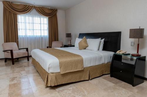 坎佩切海景酒店的酒店客房带一张大床和一把椅子