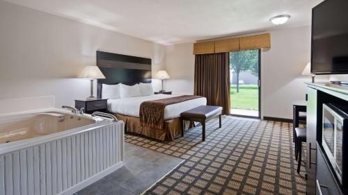 格兰德港贝肯贝斯特韦斯特酒店的酒店客房带一张床和浴缸