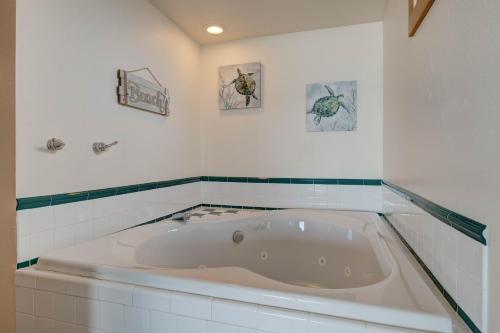 林肯市Ester Lee Motel的浴室设有浴缸,墙上有三幅画
