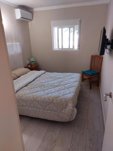 德尼亚Casa Giulia的一间卧室设有一张床、一个窗口和一把椅子