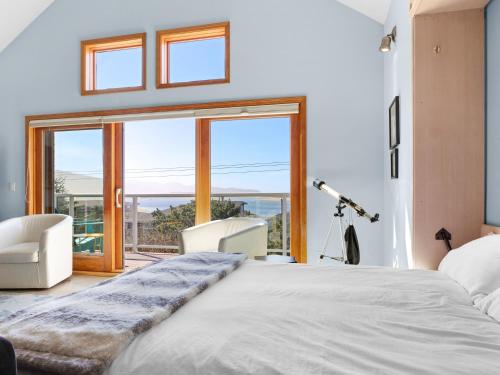 蒂拉穆克Shoreline Solace: Ocean View Townhouse Tillamook的一间卧室设有一张大床和大窗户
