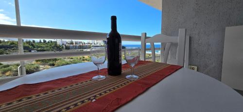 波多·纳奥斯Apartamento Sol y Playa Puerto Naos的一张桌子上放着一瓶葡萄酒,放上两杯