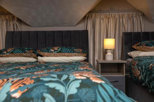 Newtownstewart城堡旅馆的一间卧室配有两张床和一盏灯及窗帘