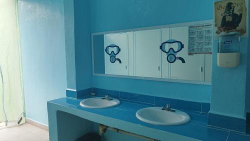 科苏梅尔Blue Magic Hostel的蓝色的浴室设有两个盥洗盆和镜子