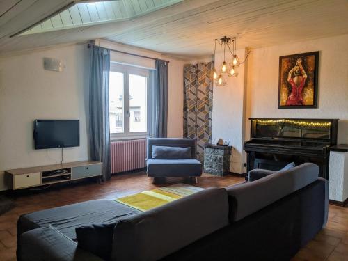 伊斯普拉Lago Maggiore - Loft Apartment的带沙发和钢琴的客厅