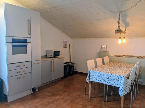 伊斯普拉Lago Maggiore - Loft Apartment的厨房配有桌子和白色冰箱。