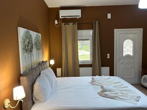 萨莫色雷斯Akrotiri studios的一间卧室配有一张带白色床单的大床