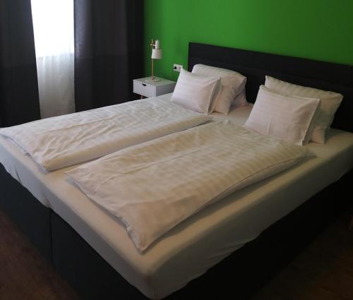 弗劳恩基兴DOMS Gästehaus的一张配有白色床单和绿色墙壁的大床