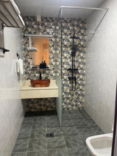 阿吉曼شقة فندقية ALzorah Ajman - الزوراء عجمان的浴室配有盥洗盆和带镜子的淋浴