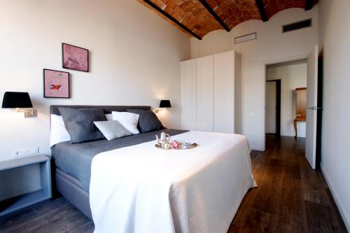巴塞罗那Decô Apartments Barcelona-Diagonal的卧室配有一张白色大床,上面有托盘