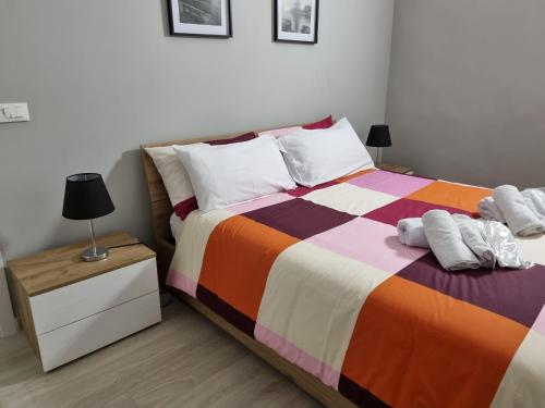 卡萨莱蒙费拉托Cà Fiamma的一间卧室配有一张带彩色毯子和床头柜的床