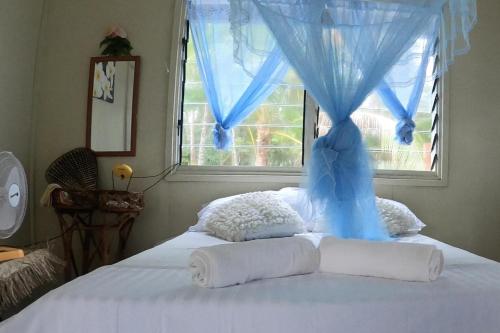 welcome to putuo ecolodge hidden germ of Solomon的一间卧室配有一张蓝色窗帘的床
