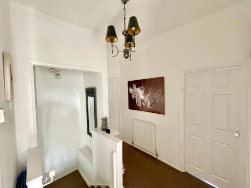 霍利黑德克里德凡公寓的走廊上设有白色门和吊灯