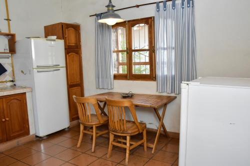 蒂尔卡拉Rincon de Sueños的厨房配有桌子、两把椅子和冰箱