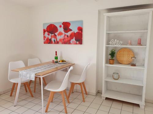 罗斯托克Charmante Maisonnette-Dachgeschosswohnung in zentraler Lage的一间带桌子和白色椅子的用餐室