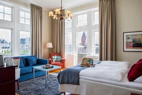 马尔默斯堪迪克广场酒店的一间卧室配有一张床、一张沙发和窗户。