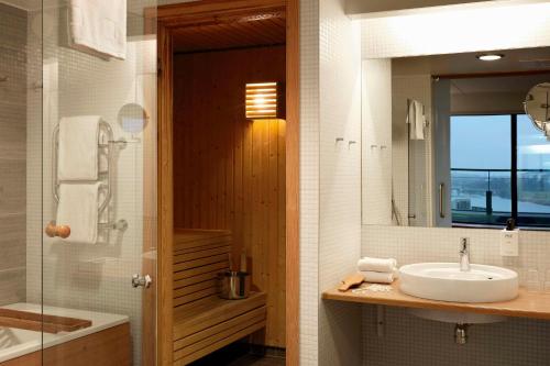 斯德哥尔摩斯堪迪克艾维克酒店的浴室配有盥洗盆、镜子和浴缸