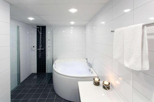 马尔默斯堪蒂克翠安格酒店的白色的浴室设有浴缸和水槽。