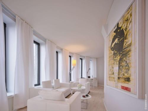 柏林Dorint Kurfürstendamm Berlin的客厅配有白色家具和墙上的绘画