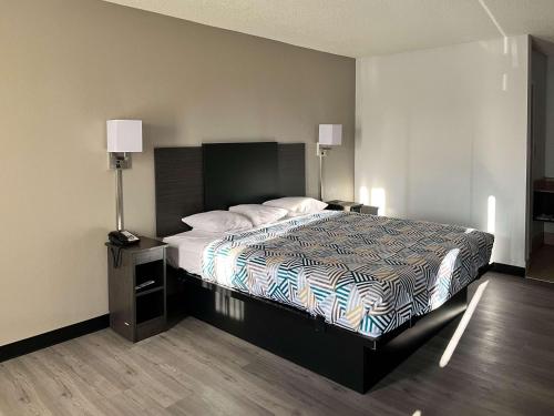蒙哥马利Motel 6 Montgomery, AL - Eastern Blvd.的一间卧室配有一张床、两个床头柜和两盏灯。