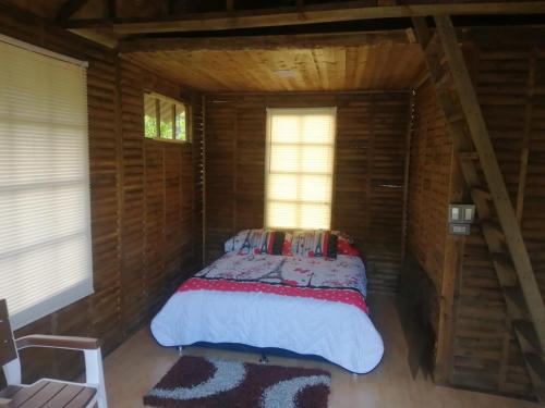 PanquebaHotel Campestre Cabañas de la Sierra Nevada de El Cocuy的小木屋内一间卧室,配有一张床