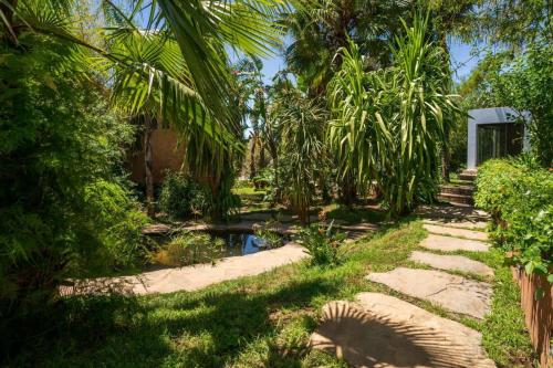 舍夫沙万莫利诺花园酒店的一个带池塘和棕榈树的花园