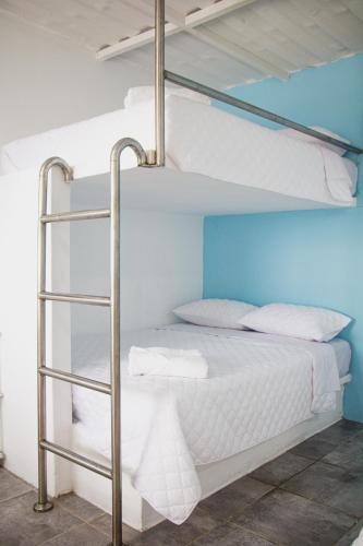 AtitancitoPacífico Cielo Eco Hotel的卧室配有2张双层床和白色床单