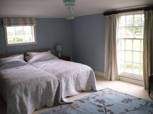 QuatfordFerienhaus für 3 Personen 1 Kind ca 80 qm in Quatford, England West Midlands的一间卧室设有两张床和两个窗户。