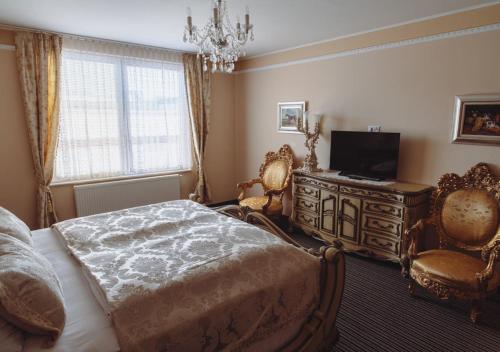 采列格兰德酒店的卧室配有床、电视和椅子