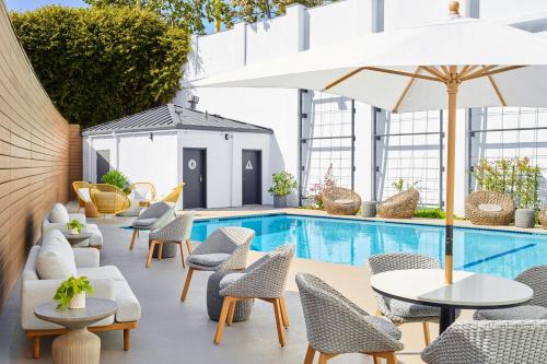 洛杉矶The Pierside Santa Monica的一个带桌椅的户外庭院和一个游泳池