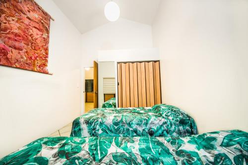 阿鲁坦加卡帕卡帕度假屋的一间卧室设有两张床,墙上挂着一幅画